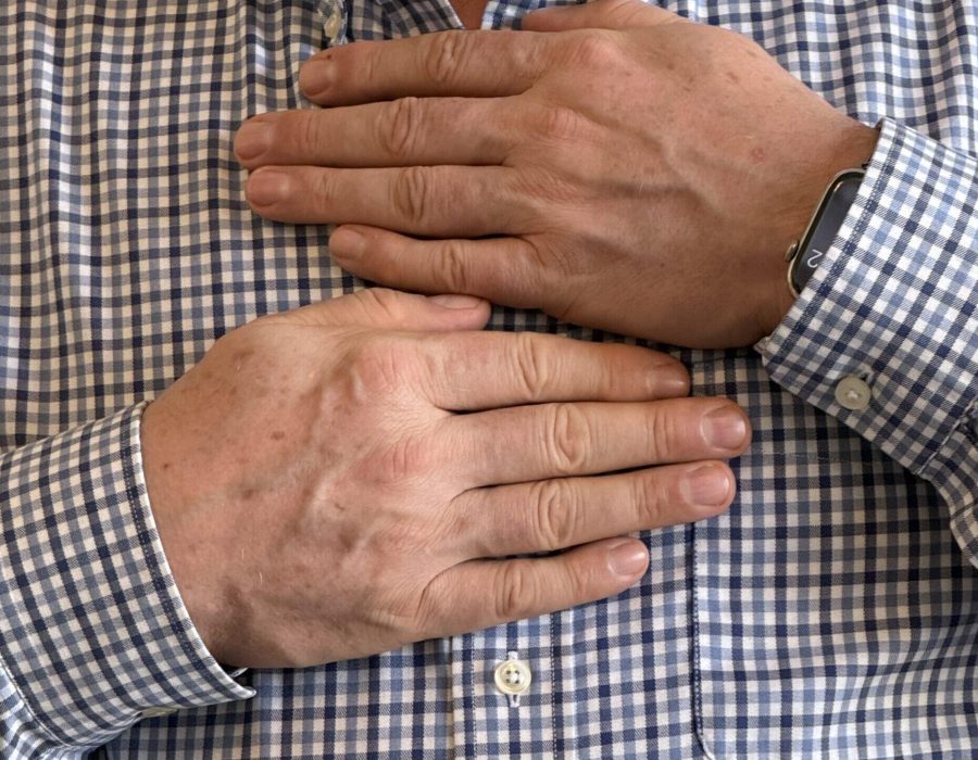 Brian Brunius demonstrates the positions of Reiki self-treatment, with his hands on the center of his chest.